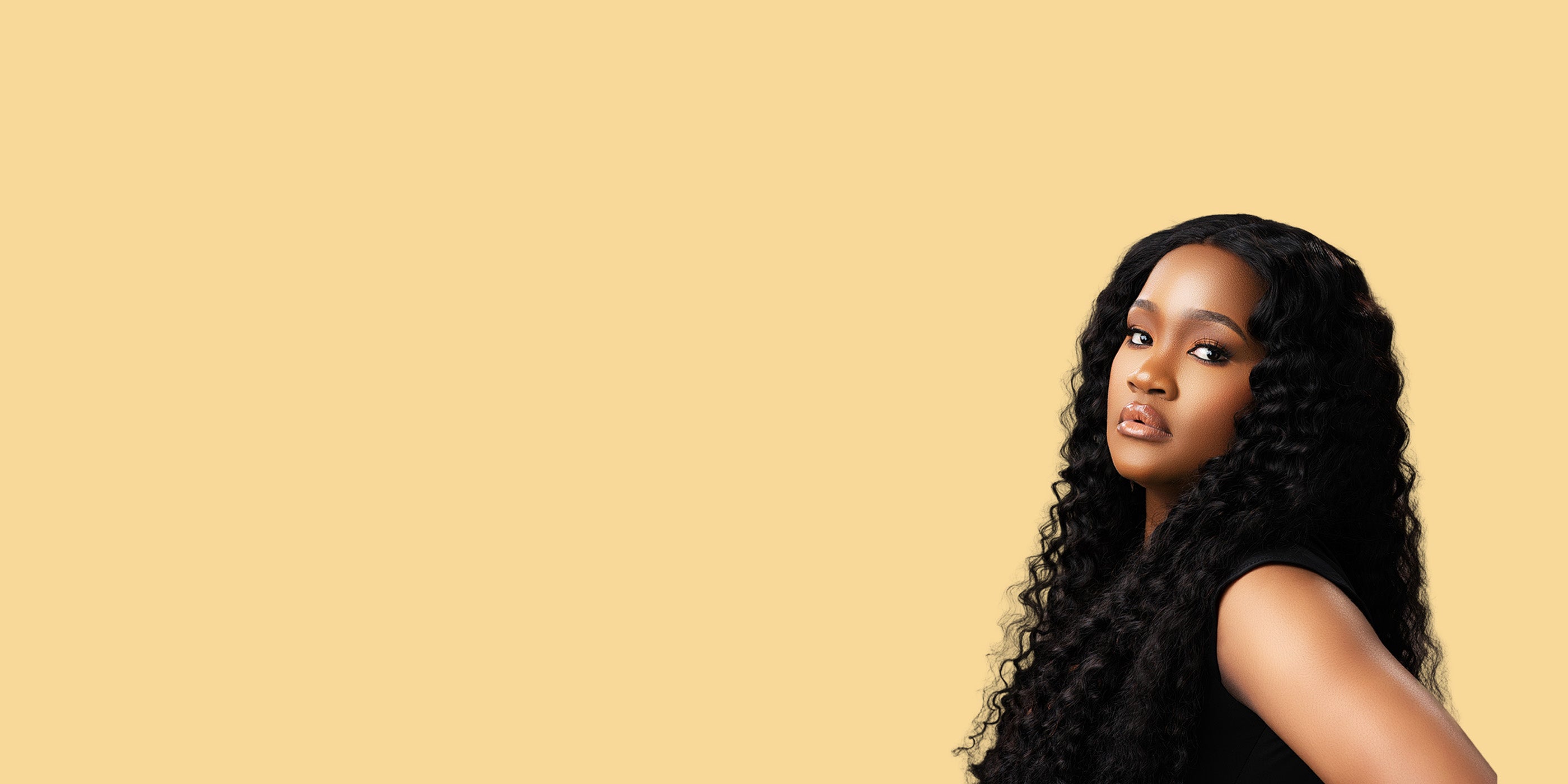 Woman with long, wavy hair against a beige background